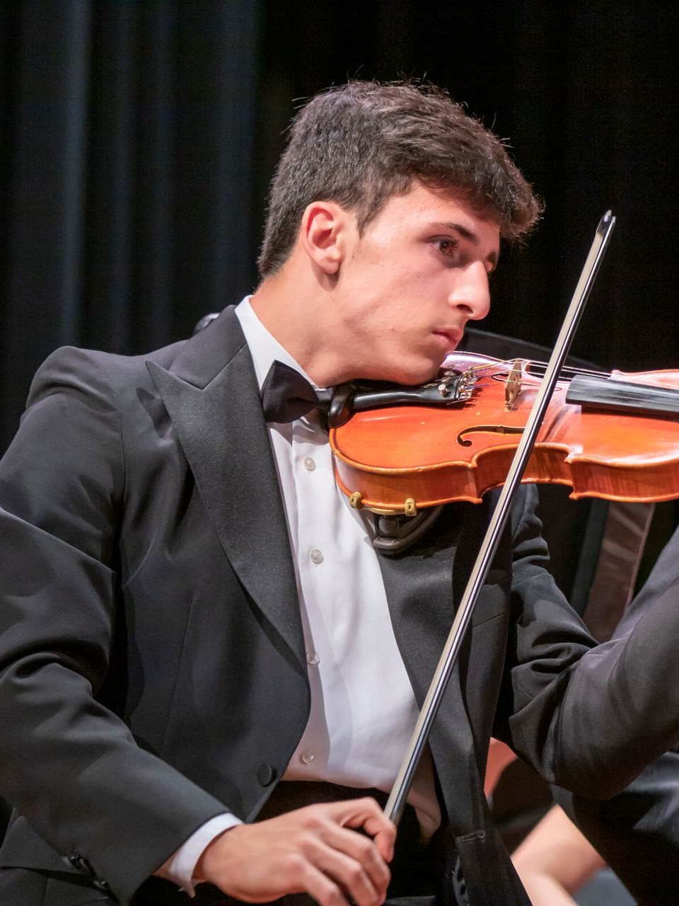 A student violinist playing, side profile